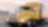 a yellow truck driving down a road at dusk