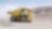yellow dumper truck driving through gravel