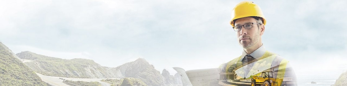 A worker in a yellow hard hat transposed onto a background og a road in some mountains
