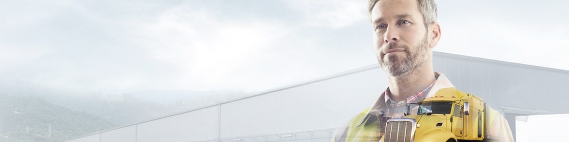 man reading a document transposed onto a background of a site and yellow truck