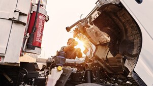 Man checking truck engine