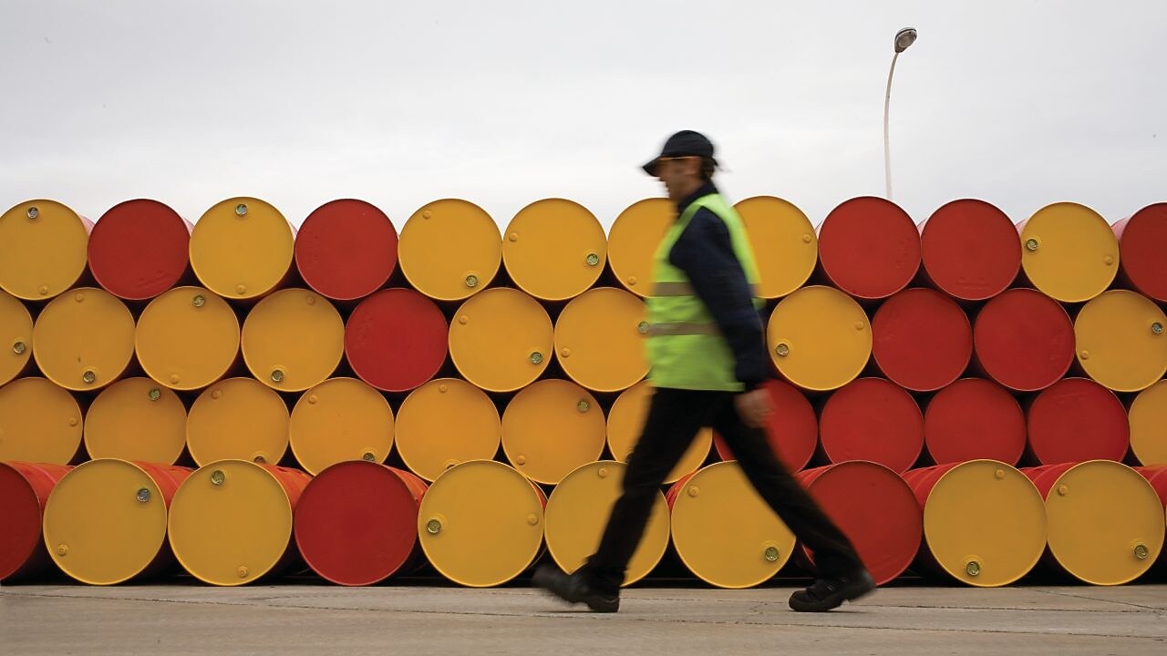 Man walking barrels lubricants