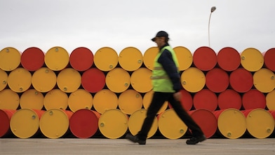 Man walking barrels lubricants