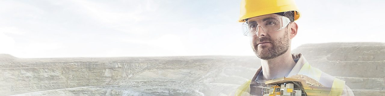 worker in yellow hard hat transposed onto a background of cliffs and a large yellow truck