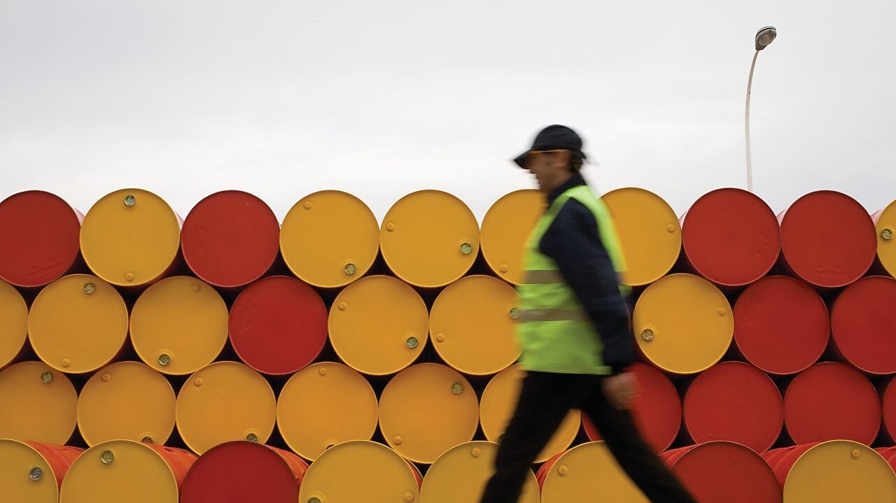 man walking barrels lubricants