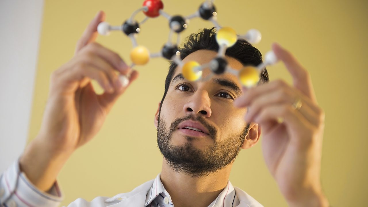 Young man examining molecular model