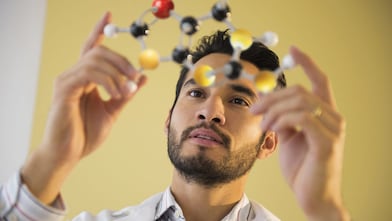 Young man examining molecular model