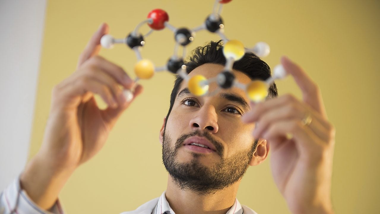 Young man examining molecular model