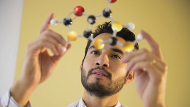 Young man examining molecular model