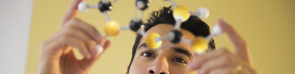 Young man examining molecular model