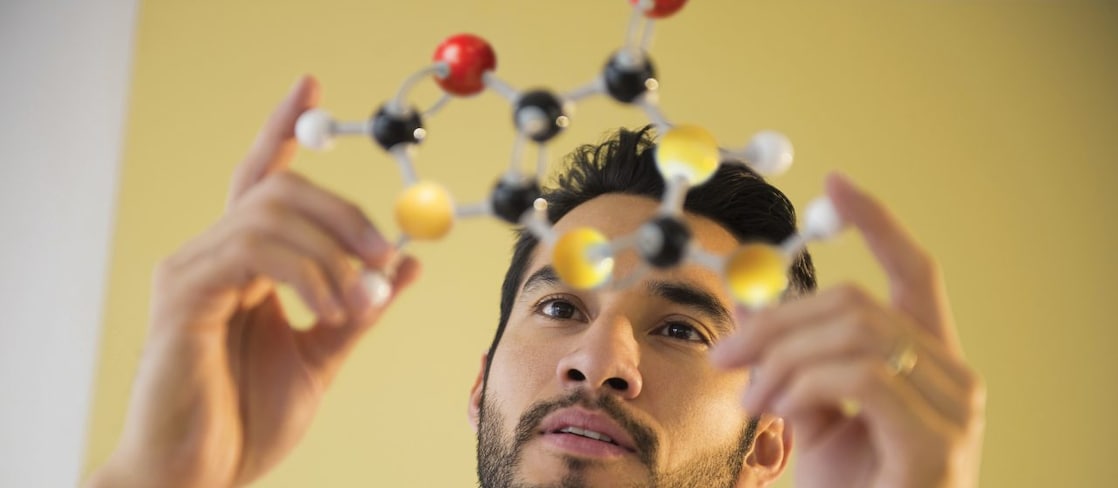 Young man examining molecular model