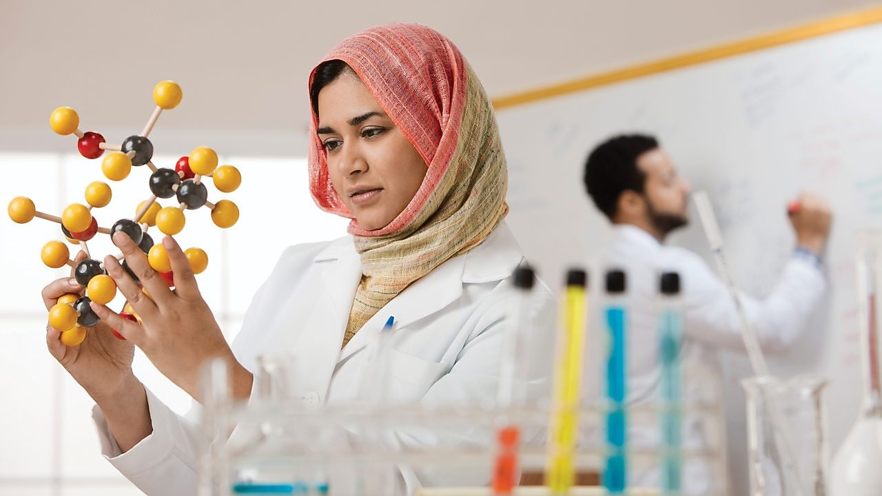 Young female scientist examining a molecular model
