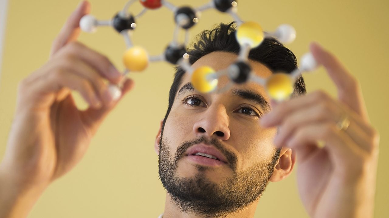 Young man examining molecular model