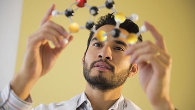 Young man examining molecular model