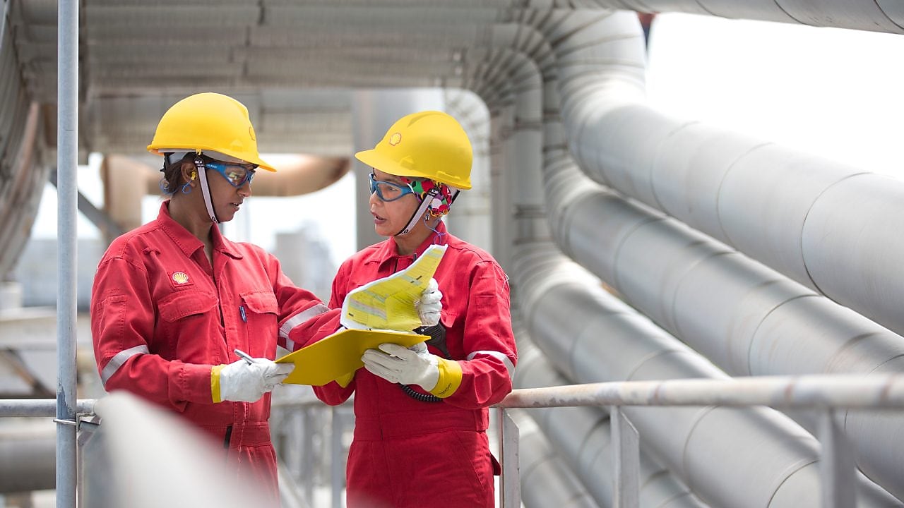 two workers discussing a project in a refinery in Malaysia