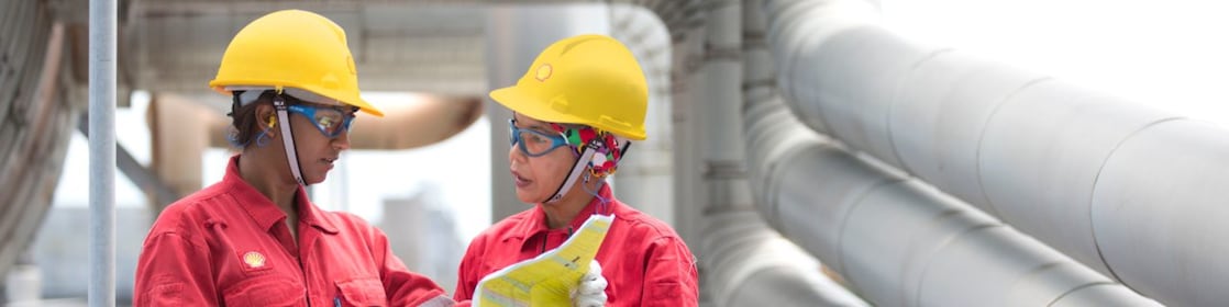 two workers discussing a project in a refinery in Malaysia