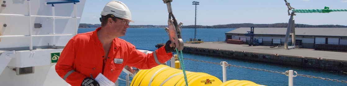 Employee inspectring equipment on a docked boat