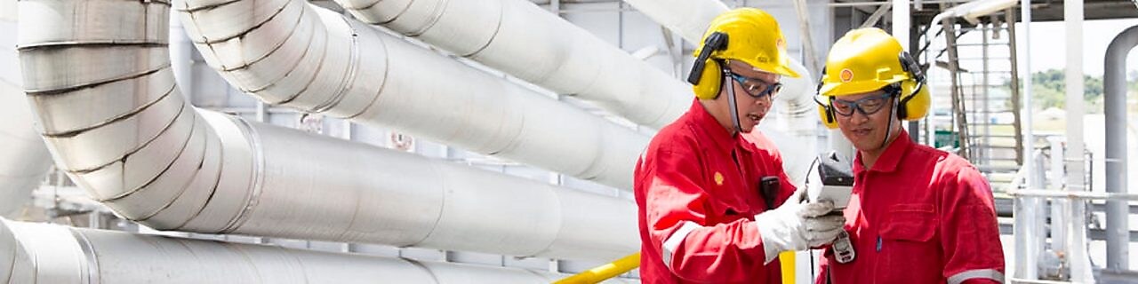 Two engineers looking at equipment in hand