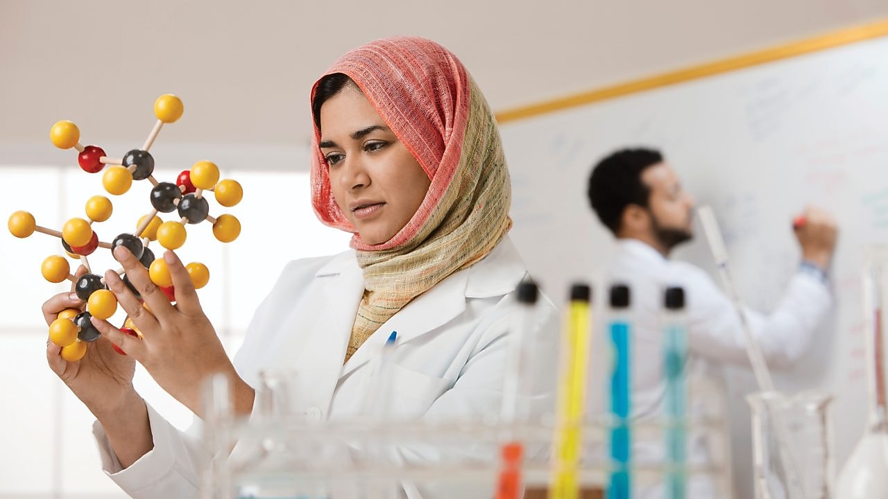 Young female scientist examining a molecular model