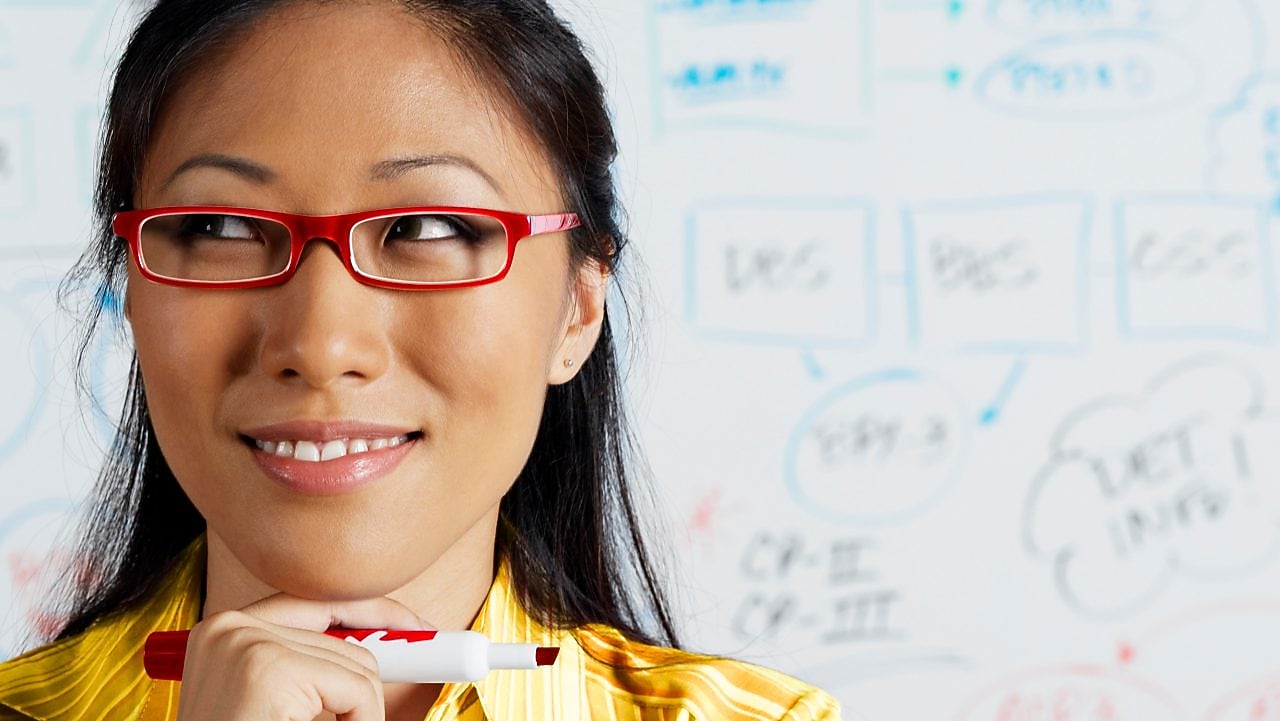 Close up of Asian businesswoman smiling in front of whiteboard