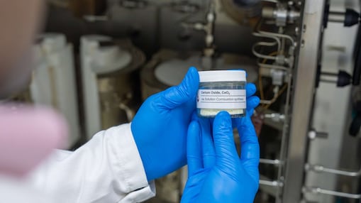 A male wearing a Shell branded laboratory coat is standing in a research laboratory carrying out tests.
